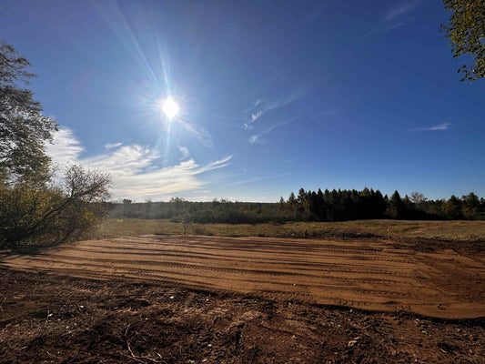 leveled dirt pad with blue sky and sun